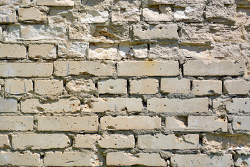 The wall is made of gray bricks with strong potholes.