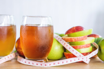 fresh green and red apple slice and juice glasses with measuring tape, healthy fruit and drink for weight control in summer