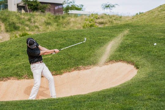 Man Hitting Golf Ball Out Of A Bunker