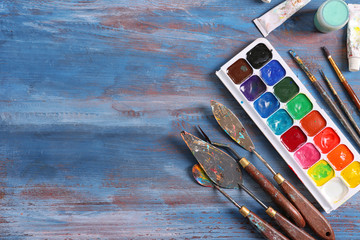 Set of painting tools on wooden table, flat lay