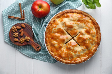 Tasty homemade apple pie on white wooden table