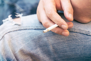 Cigarette in the hands of a seated man