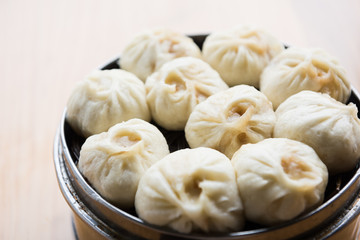 Fototapeta na wymiar Asian Cuisine. Steamed dumplings in a bamboo steamer. 