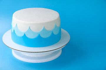Сake for the child's birthday, decorated with sea waves on a blue background. Picture for a menu or a confectionery catalog.
