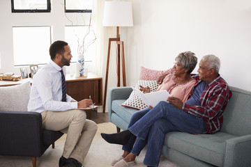 Senior Couple Meeting With Male Financial Advisor At Home