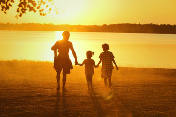 Happy loving family. Dad and his daughter playing outdoors. Father took the baby learn to walk at sunset.