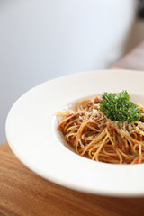 spaghetti Bolognese with minced beef and tomato sauce garnished with parmesan cheese and basil , Italian food