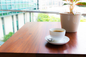 Black coffee in a cup on a wooden table