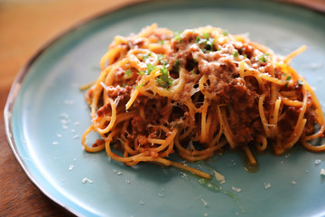 spaghetti Bolognese with minced beef and tomato sauce garnished with parmesan cheese and basil , Italian food