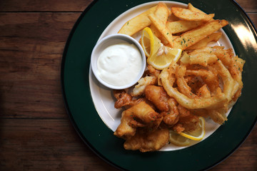 Fish and chips fried fish and potatoes on wood background vintage style