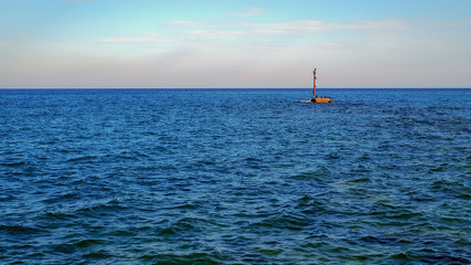 Fototapeta premium Seascape with black sea birds loafing on the rock near the beach