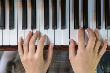 Asian Woman hands playing the piano in top view