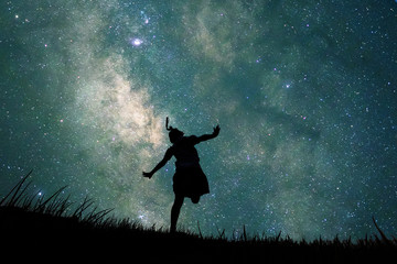 Silhouette of student girl running in glass fields and full of stars in the sky at night. Concept...