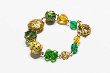 A bracelet with gold, amber and emerald elements. Jewelry.