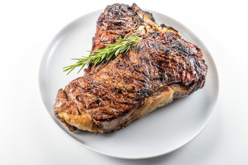 White round plate with Whole grilled T-bone steak and rosemary