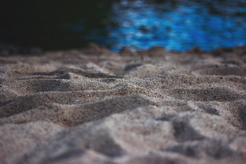 Fototapeta na wymiar Golden sand dunes and the sea. The effect of the macro on the beach