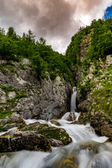 Naklejka na ściany i meble Tranquillo flusso d'acqua delle piccole cascate vicine alla sorgente del fiume Isonzo, ne Parco nazionale del Triglav, Slovenia