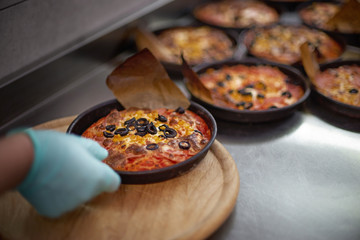 Preparation Mini pizza for children, on an iron table