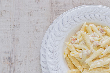 Pasta penne with sausage and cream with negative space.