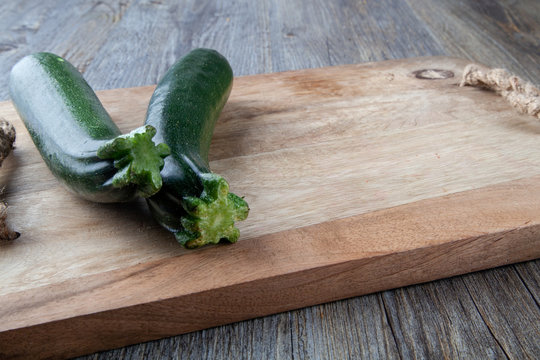 Two Courgettes on a wooden chopping board
