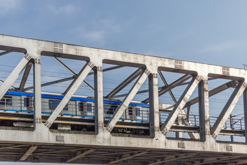 Unidentified metro train iron bridge with zigzag lines built using modern day technology in India.Seen with moving metro train.