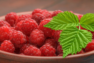Close-photographed berries of a raspberry in a ceramic dish, a healthy diet