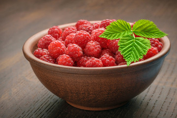 Organic food of red raspberries, wooden oak table
