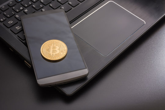 cryptocurrency called bitcoin with laptop and a smartphone.