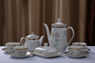 White porcelain tea set with flowers on a tablecloth