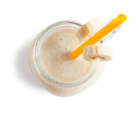 Banana milkshake in a glass jar (mason jar), isolated on white background.