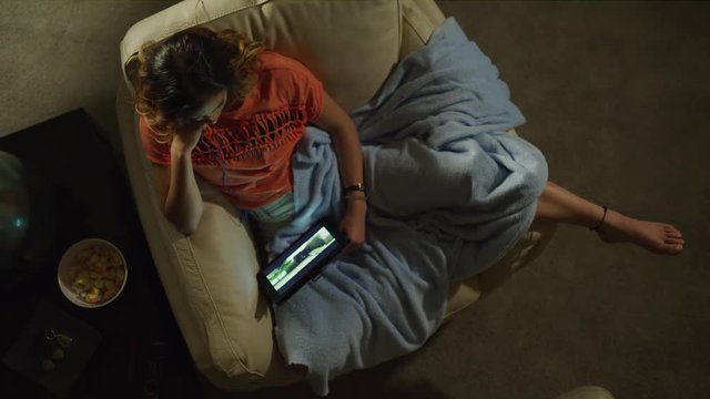 Crane shot zoom in on teenage girl streaming movie on digital tablet / Cedar Hills, Utah, United States