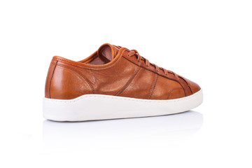 Close up of a brown men's sneakers shoes on white background with reflection. Fashion advertising...
