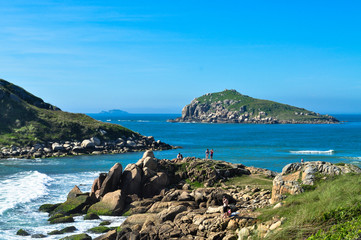 Fototapeta na wymiar Tourists in the blue sea with green island background