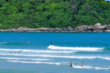 Surfing on the blue sea with green island background