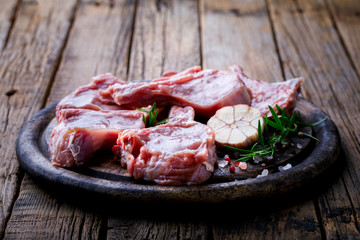 Raw fresh meat Veal rib Steak on bone and meat fork  on a wooden vintage background with spices garlic and rosemary  Copy space for Text