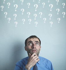 Caucasian businessman with questions. Choice and confusion concept