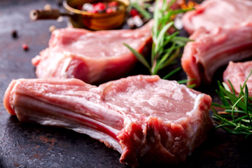 Meat Raw Fresh Mutton on the bone Spices Chesno and Rosemary on a black background