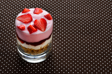Home made granola breakfast with strawberries and plain yogurt, served in the glass.