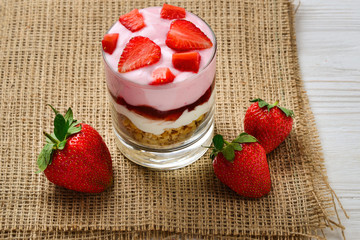Home made granola breakfast with strawberries and plain yogurt, served in the glass.