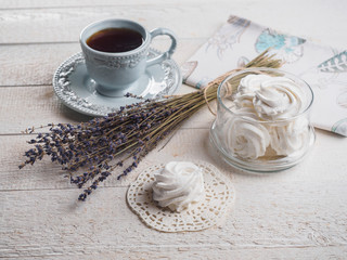 White homemade zephyr with cup of tea on the wooden boards