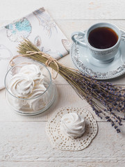 White homemade zephyr with cup of tea on the wooden boards
