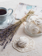 White homemade zephyr with cup of tea on the wooden boards