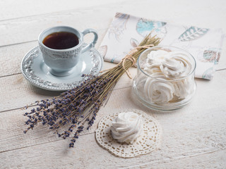 White homemade zephyr with cup of tea on the wooden boards