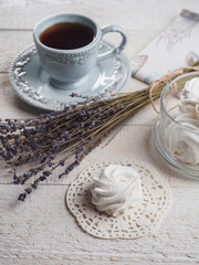 White homemade zephyr with cup of tea on the wooden boards