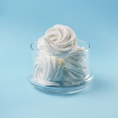 White homemade zephyr on glass crocheted jacket. blue isolated background