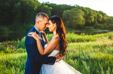 bride and groom on their wedding day, nature walks, kiss and hugs, sunset