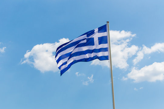 The greek flag blowing in the blue sky