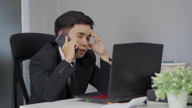 depressed man in suit is talking on smartphone