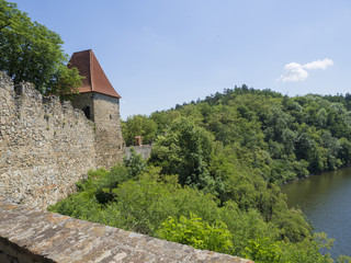Fototapeta na wymiar view from rampart of medieval castle Zvikov (Klingenberg), wall with tower, vltava river, spring green trees and blue sky, Czech Republic