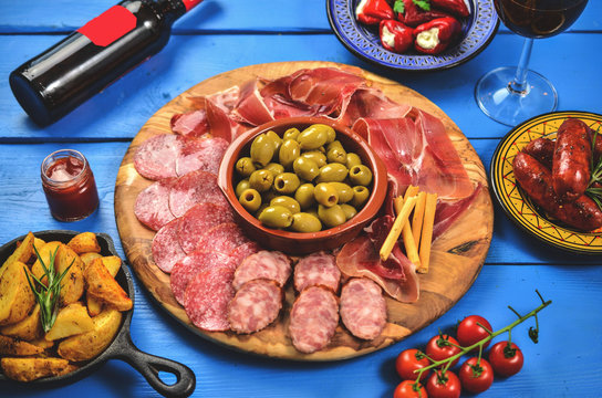 Spanish tapas on wooden table, top view